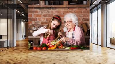 Grandmother and cute granddaughter cooking healthy food at home at kitchen Wall mural