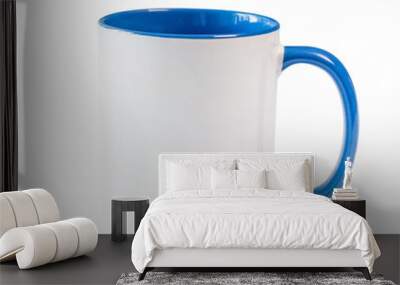 White cup with blue handle and inner surface on a white table Wall mural