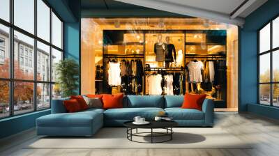 Multiple clothes for sale in the showcase of modern fast-fashion collection and two mannequins presenting the t-shirts in stripes Wall mural