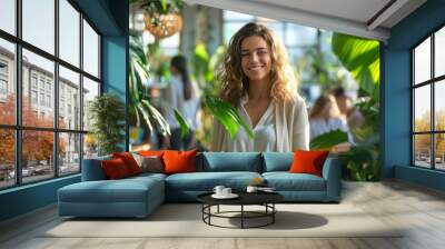 A young woman is walking through the open space office, smiling and looking at her team members working at their desks in the background Wall mural