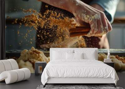 A person is busy in the kitchen, sprinkling cinnamon and nutmeg onto a batch of food on a table, Sprinkling cinnamon and nutmeg over a batch of cookie dough Wall mural