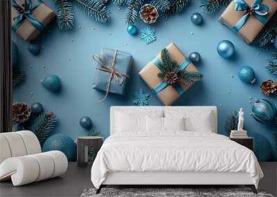 A Christmas greeting card template featuring gift boxes, blue balls, and fir branches on a pastel blue table, providing a flat lay composition for a New Year poster design. Wall mural