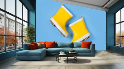 A pair of child yellow rain boots on blue background Wall mural