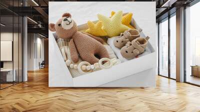 Box with baby stuff and accessories for newborn on bed. Gift box with knitted blanket, clothes, socks, shoes and toy. Baby shower concept.  Flat lay, top view Wall mural