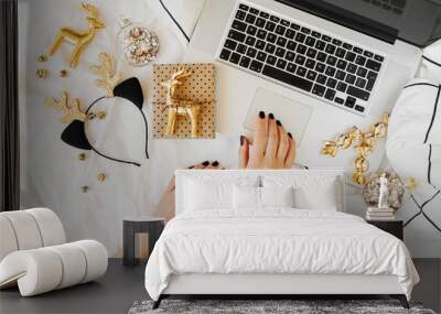 Christmas online shopping.  Woman buys presents online. Laptop with Christmas decorations on white bed with a blanket. Holiday concept. Flat lay, top view Wall mural