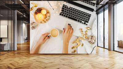 Christmas online shopping.  Woman has coffee, buys presents online. Laptop with Christmas decorations on white bed with a blanket. Holiday concept. Flat lay, top view Wall mural