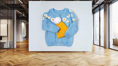 Cute blue knitted children's jacket with yellow hat. Stylish kids clothes for spring, autumn or winter. Fashion outfit. Flat lay, top view Wall mural