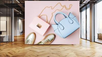 Fashion handbags with shoes on pale pink background. Flat lay, top view. Spring/summer fashion concept in pastel colored Wall mural