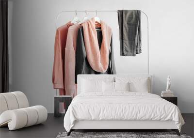 Female clothes in pastel pink and gray color on hanger on white background.  Jumper, shirt, jeans and scarf. Spring/autumn outfit. Minimal concept. Wall mural