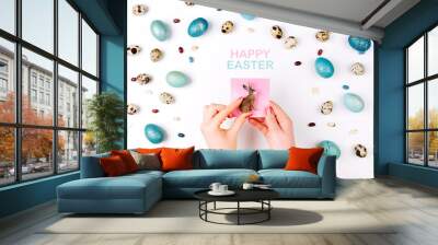 Happy Easter card. A woman is holding a rabbit against the background of Easter eggs. Copy space for your text Wall mural