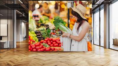 Young Woman puts fruits and vegetables in cotton produce bag at food market. Reusable eco bag for shopping. Zero waste concept. Wall mural