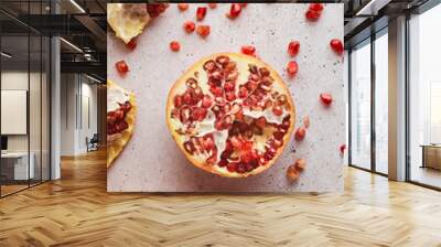 Half open pomegranate on white stone background.Top view. Macro shot. Wall mural