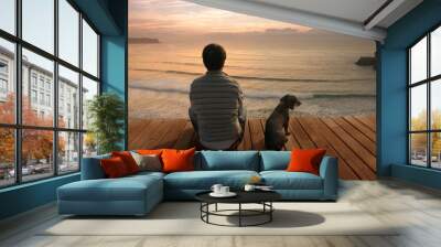 silhouette of man sitting on pier at sunset Wall mural