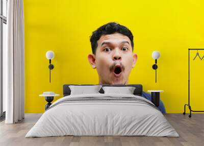 Portrait of the face of an Asian young man with a shocked expression. Studio shoot Wall mural