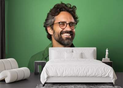 Handsome bearded man with glasses and a green shirt on a green background Wall mural