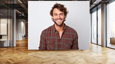 Handsome young man in checkered shirt smiling and looking at camera. Wall mural