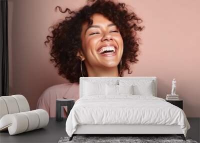 Portrait of a beautiful young african american woman laughing against pink background Wall mural