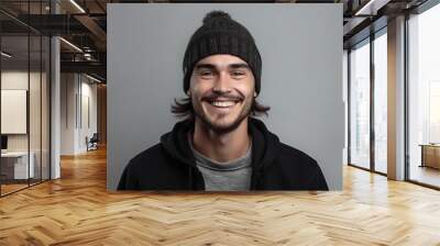 Portrait of a handsome young man in winter hat on grey background Wall mural