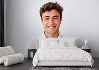 Portrait of a handsome young man smiling at camera over white background Wall mural