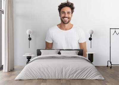 Portrait of a handsome young man smiling while standing against white background Wall mural