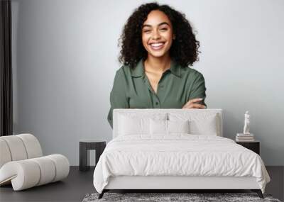 Portrait of a happy young african american woman standing with arms crossed over white background Wall mural