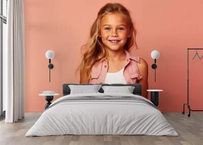 Portrait of a little girl in a pink shirt on a pink background. Wall mural