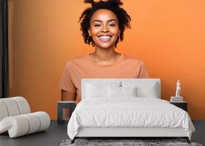 Portrait of a smiling african american woman on orange background Wall mural