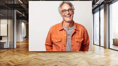 Portrait of a smiling senior man in orange jacket and glasses on white background Wall mural