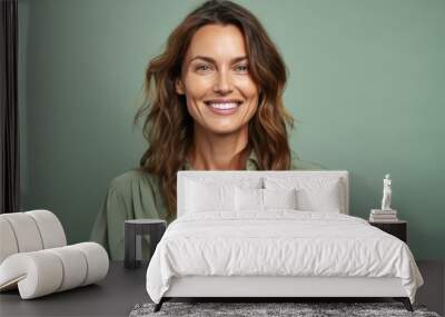 Portrait of a smiling woman looking at camera isolated over green background Wall mural