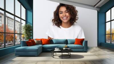 Portrait of beautiful young woman smiling and looking at camera while standing against white background Wall mural