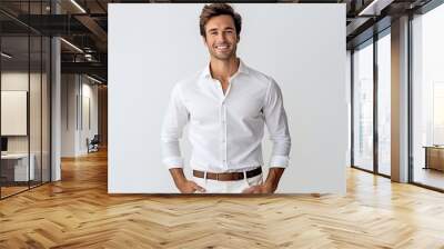 Portrait of handsome young man in white shirt looking at camera and smiling while standing against grey background Wall mural