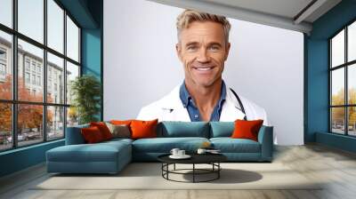 Portrait of happy mature male doctor with stethoscope smiling at camera Wall mural