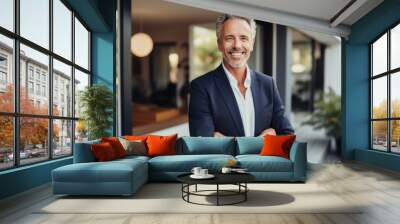 Portrait of smiling mature businessman standing with arms crossed outside office building Wall mural