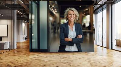 Portrait of smiling senior businesswoman standing with arms crossed in office Wall mural