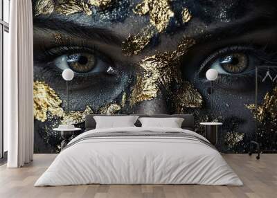   A close-up of a woman's face adorned with black and gold paint and gold leaves Wall mural