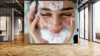 Beautiful woman washing her face with soap foam Wall mural