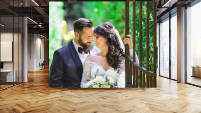 bride and groom kissing each other at the gate Wall mural