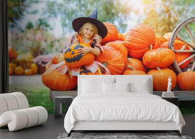 child girl als little cute witch with pumpkin outdoors in halloween Wall mural