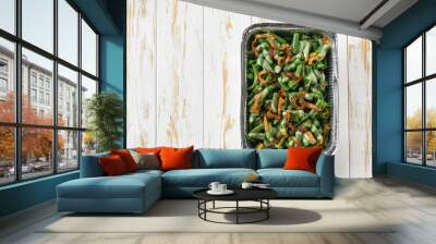 green bean casserole with crispy fried shallots onion in a disposable square aluminium foil baking dish on a white table, top view. Wall mural