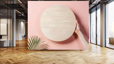 Hand Holding Wooden Circle Against Pink Background Wall mural