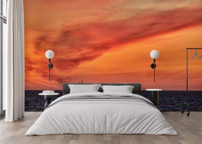 Beautiful ocean sunset , with colourful red and orange sky, dark sea and silhouette of ship on the horizon. Wall mural