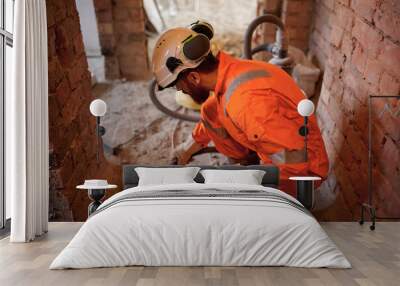 Close up of constriction site worker cleaning concrete floor with vacuum cleaner after demolishing jobs. Wall mural