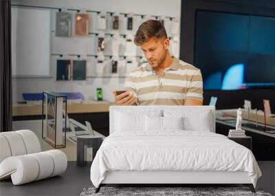 man selecting smartphone from stall Wall mural