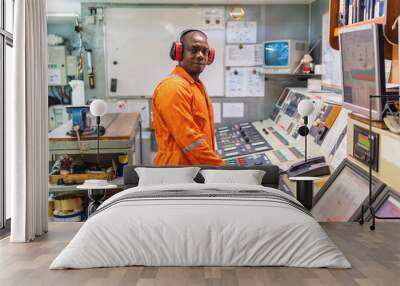 Marine engineer officer in engine control room ECR. Seamen's work. He starts or stops main engine of ship Wall mural