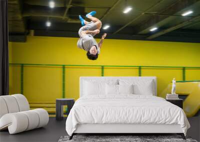 trampoline jumper performs complex acrobatic exercises and somersault on the trampoline. Wall mural