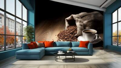 Coffee cup with burlap sack of roasted beans on rustic table Wall mural