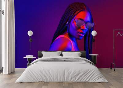 Portrait of fashion young girl in cool sunglasses in red and blue neon light in the studio Wall mural