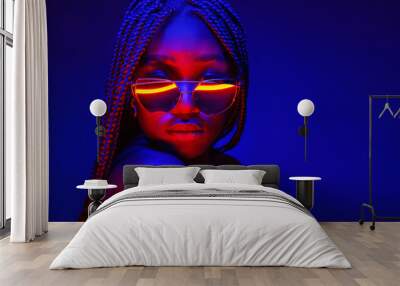 Portrait of fashion young girl in sunglasses in red and blue neon light in the studio Wall mural