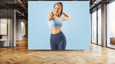 Portrait of happy fitness young woman smiling while exercising. Wall mural