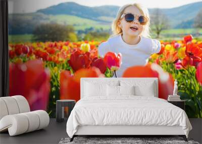 little happy girl in the tulip field Wall mural